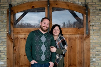 Smiling family standing at the entrance of their home with a secure steel door.