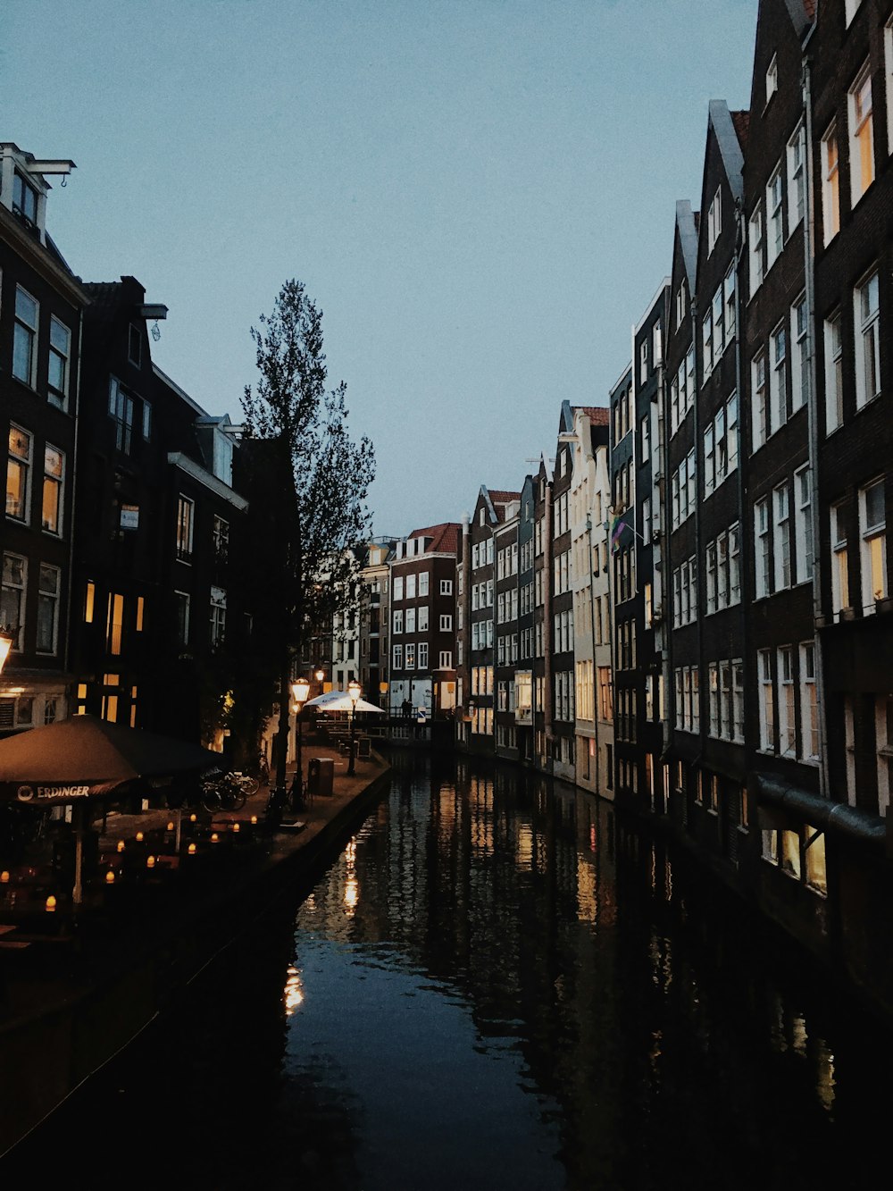 river between concrete buildings during night time