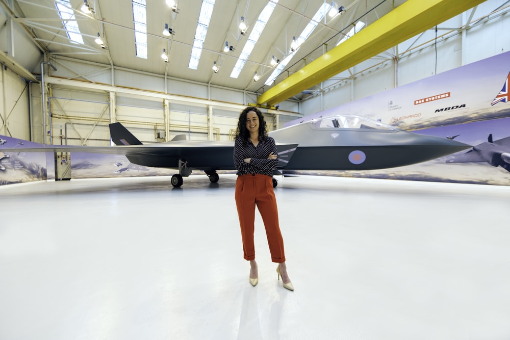 woman in black long sleeve shirt and red pants standing on white floor