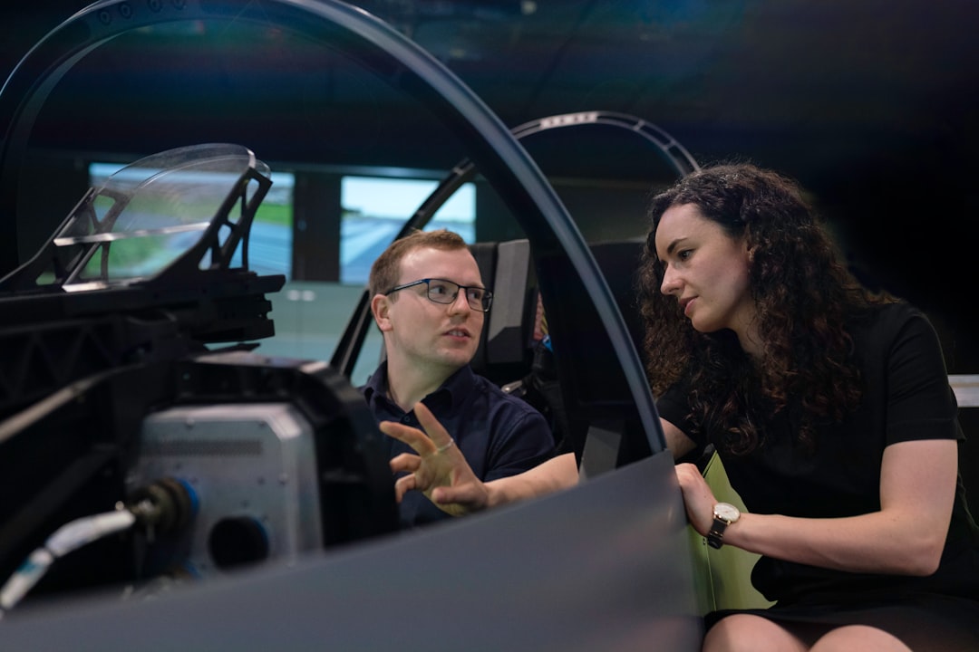 Female aerospace engineer talks with colleague in flight simulator