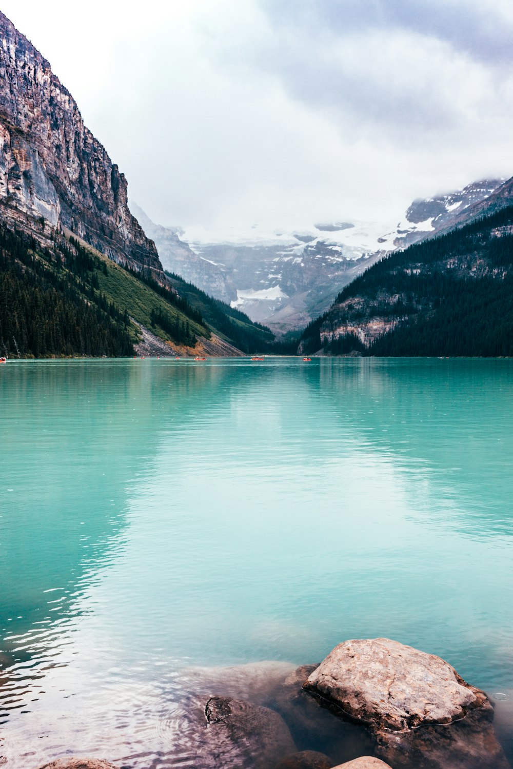 Lac vert près des montagnes vertes et brunes pendant la journée