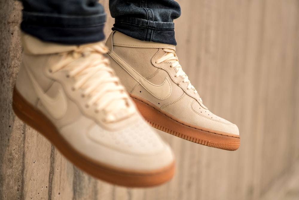 person wearing blue denim jeans and white nike air force 1 high
