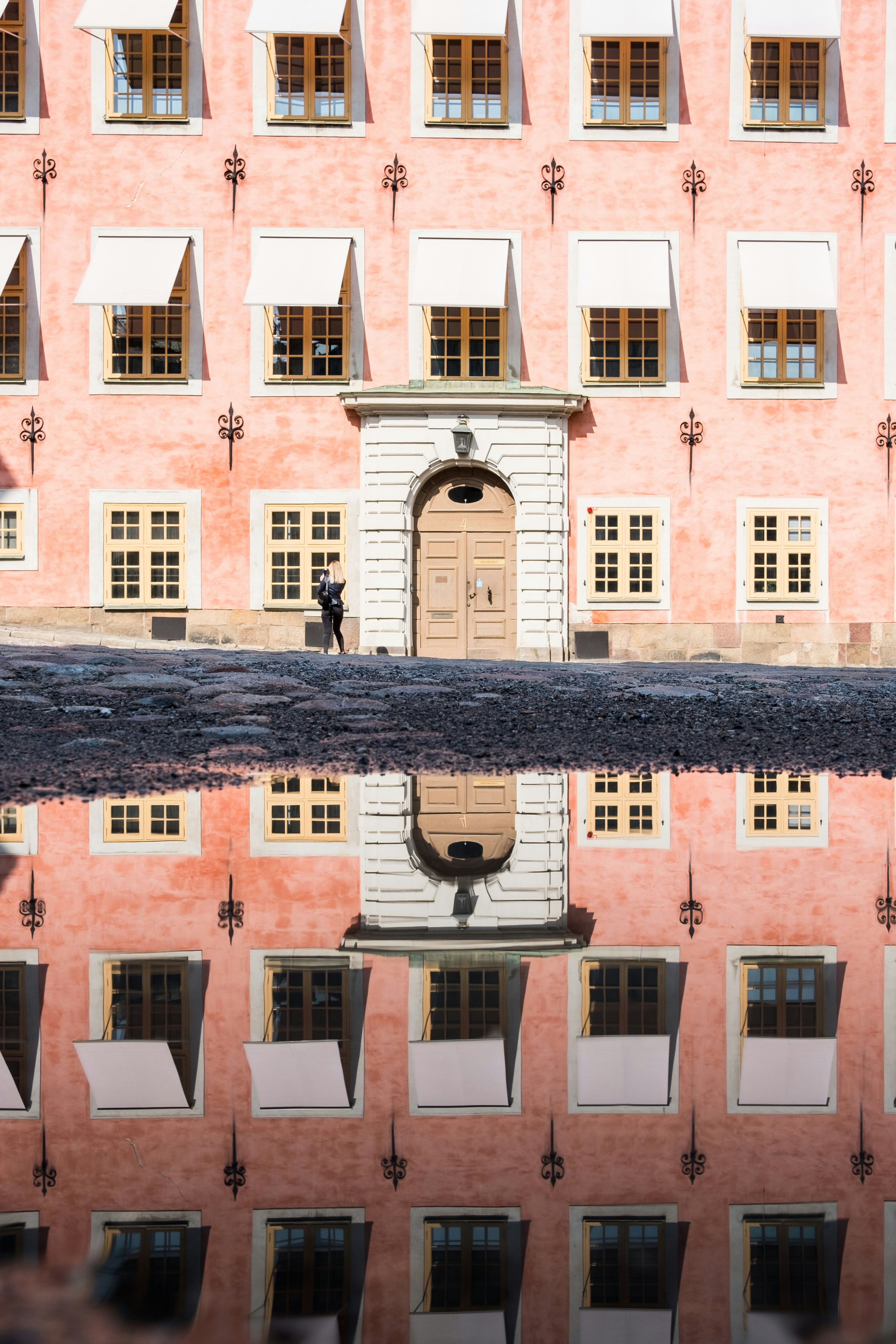 man in black shirt and black pants standing on black concrete floor during daytime