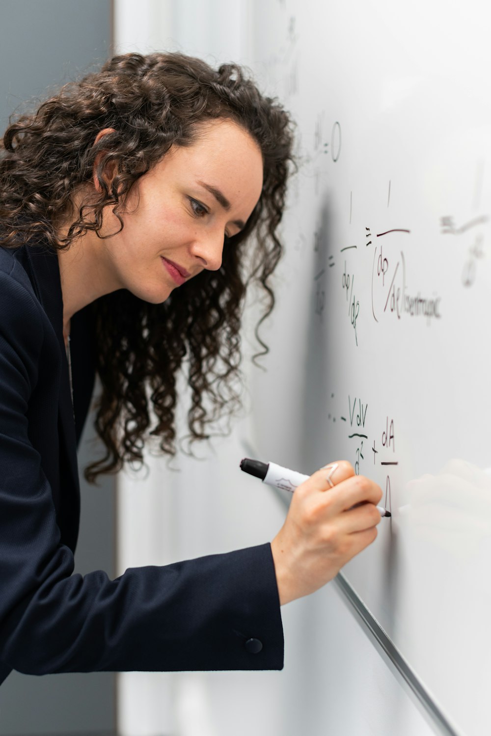 Frau in schwarzem Langarmhemd mit Stiftschrift auf weißem Papier