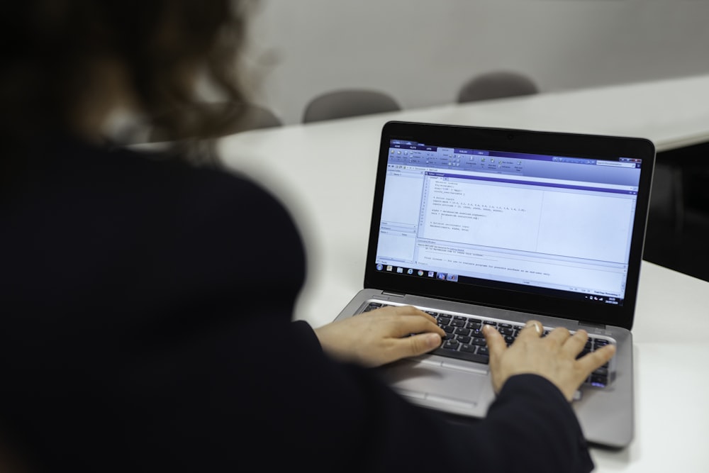 Frau im schwarzen Langarmshirt mit MacBook Pro