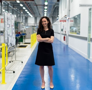 woman in black long sleeve dress standing on blue floor