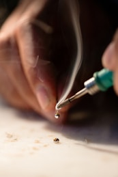 person holding soldering iron