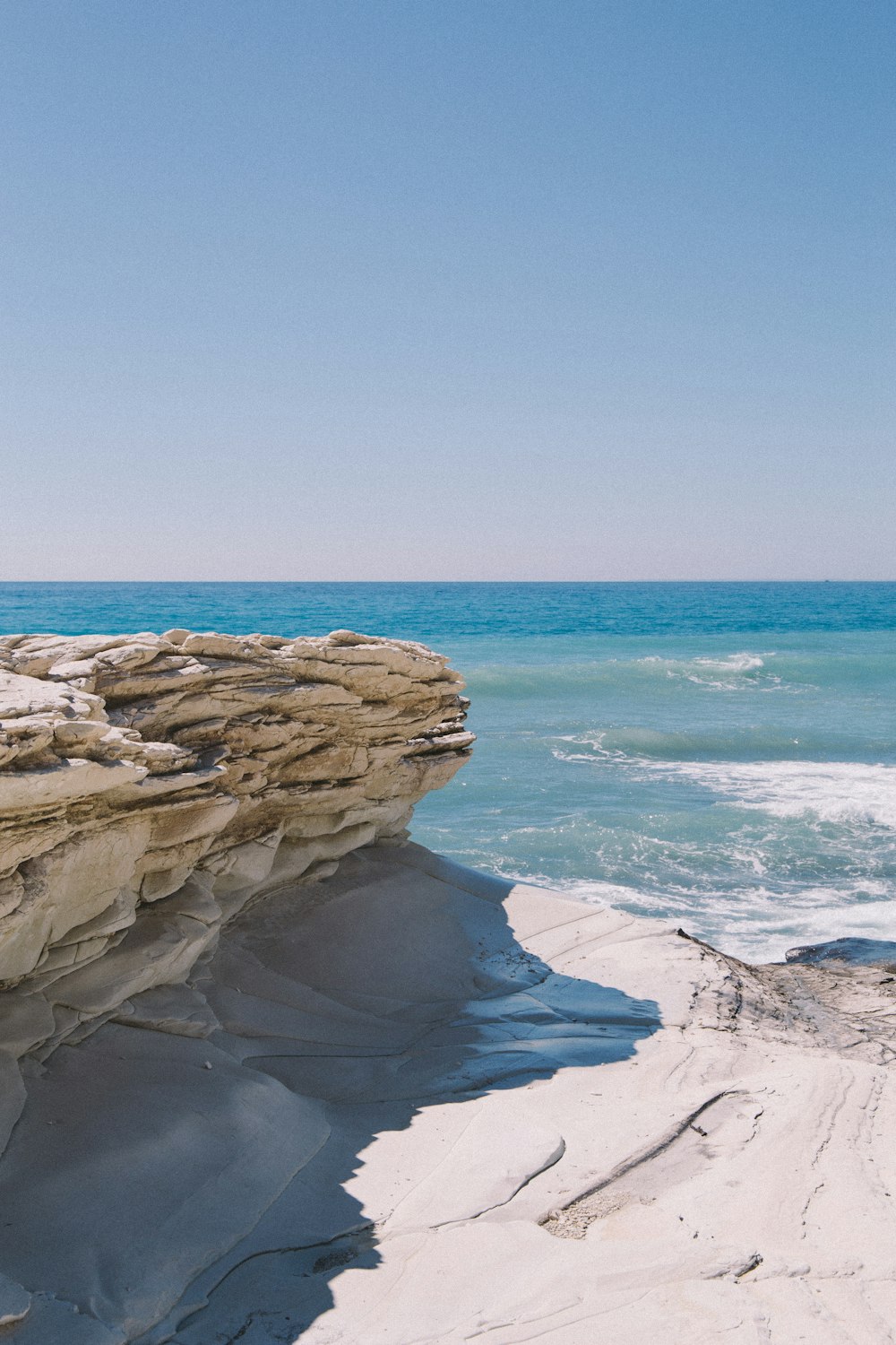 brown rock formation near body of water during daytime