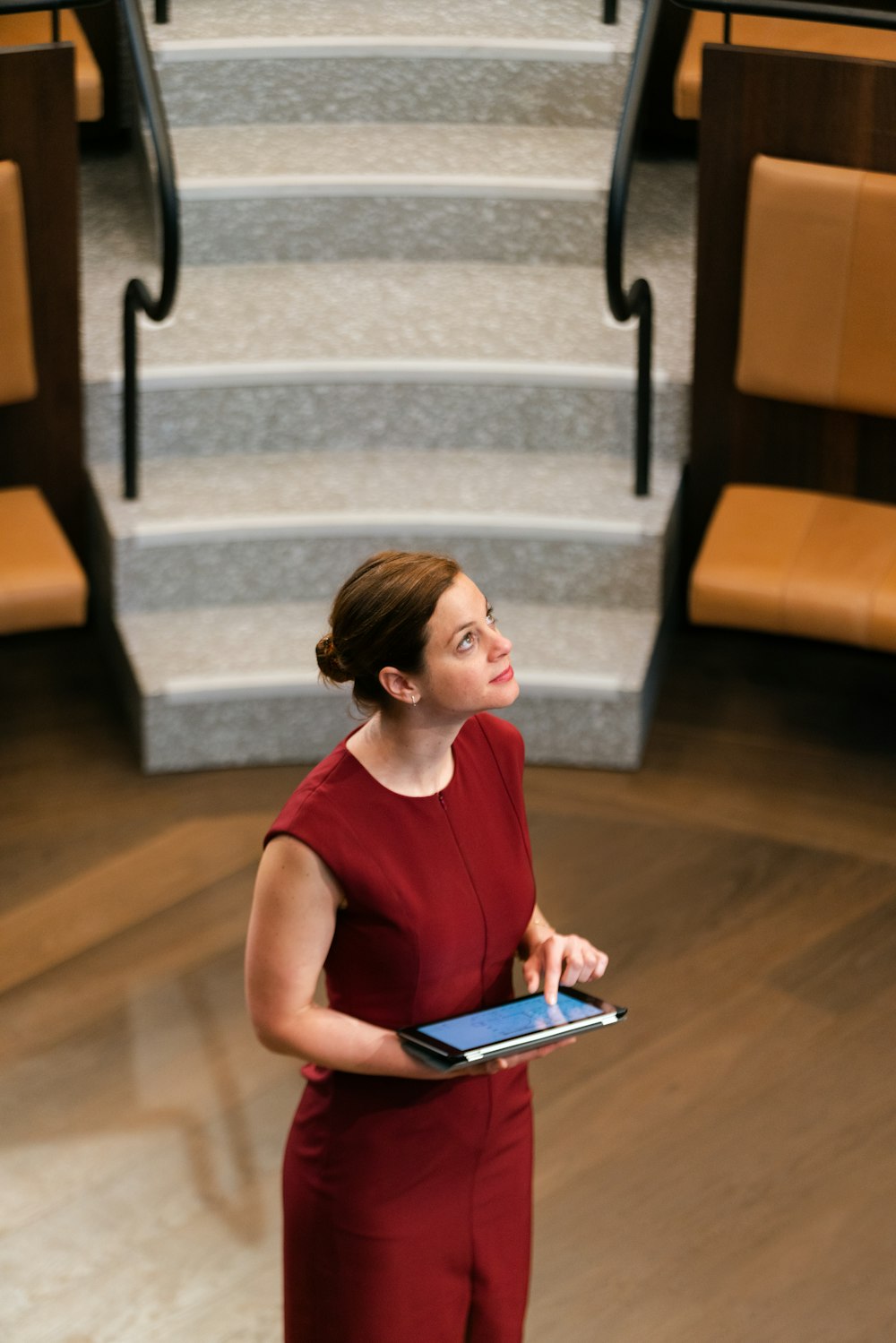 woman in red tank top using white tablet computer