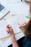 Close-up of hands writing disciplined plans on a notebook