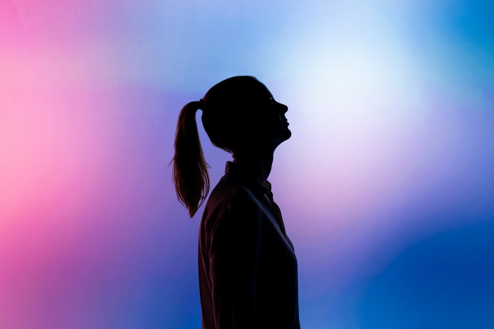 Silhouette einer Frau mit schwarzem Hut und schwarzem Mantel