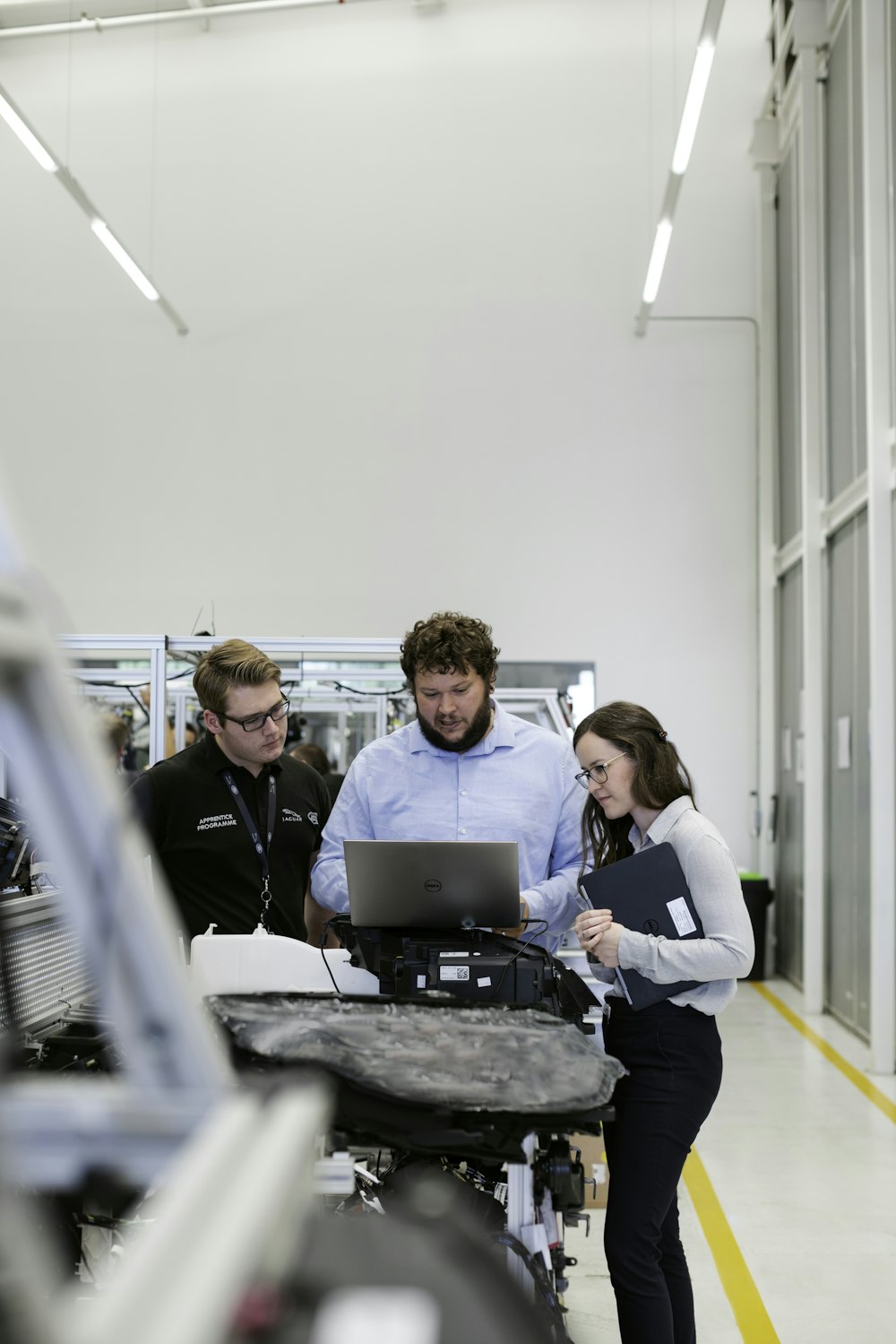 Gruppe von Menschen, die auf einem Stuhl vor einem Tisch mit Laptops sitzen