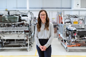 Woman in glasses on a factory floor smiling