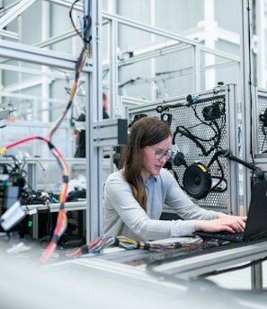 woman in white long sleeve shirt using black laptop computer