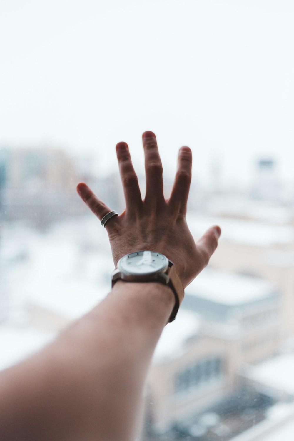 person wearing silver round analog watch with silver link bracelet