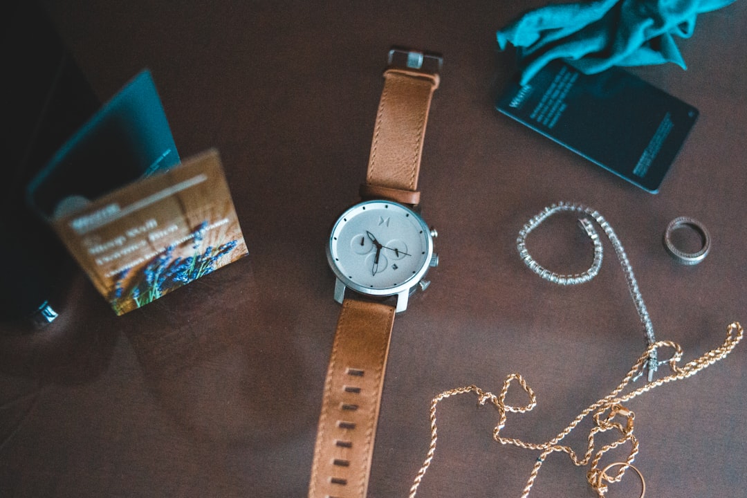 silver round analog watch with brown leather strap