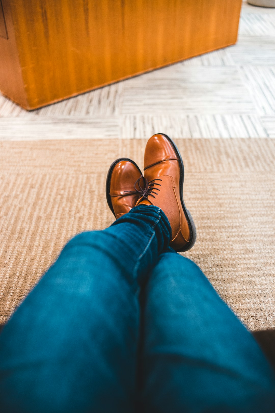 person in blue denim jeans and brown leather shoes