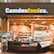 A small convenience store or food shop features a variety of snacks, drinks, and quick meals displayed on shelves, with a counter for service. The store has a wooden and brick design, with warm lighting hanging from the ceiling. Products like bottled water, chips, and packaged goods are visible.
