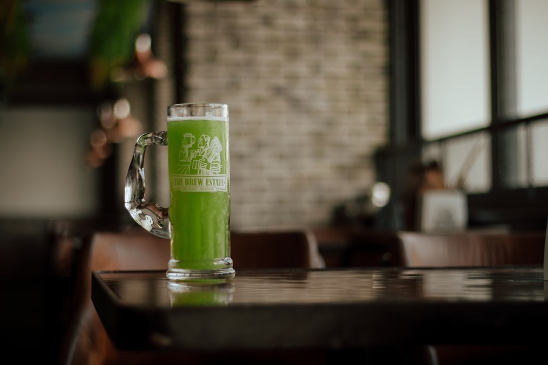 clear drinking glass with beer on brown wooden table