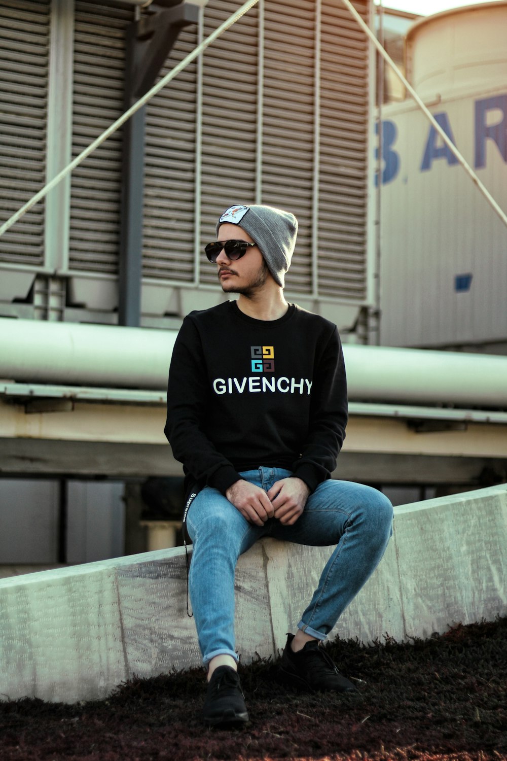 man in black and white adidas hoodie and blue denim jeans sitting on gray  wooden bench photo – Free Iranian people Image on Unsplash