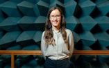 woman in white button up shirt and blue denim jeans wearing black framed eyeglasses