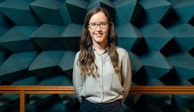 woman in white button up shirt and blue denim jeans wearing black framed eyeglasses