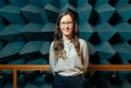woman in white button up shirt and blue denim jeans wearing black framed eyeglasses