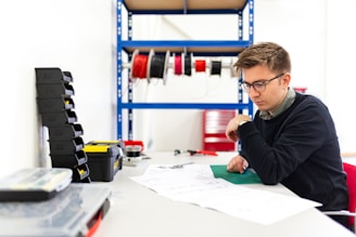 boy in black hoodie writing on white paper