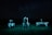 A person stands in a field at night, flanked by two robotic machines. The background is a dark night sky filled with stars. The scene is illuminated by cool-toned, artificial lighting, casting an eerie glow over the landscape.