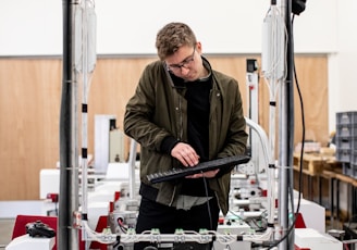 man in brown jacket using a machine