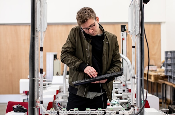 man in brown jacket using a machine