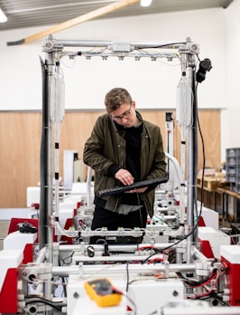 man in brown jacket using a machine