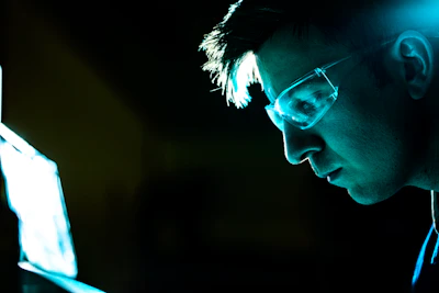 Close-up of a determined man studying with holographic digital interfaces.
