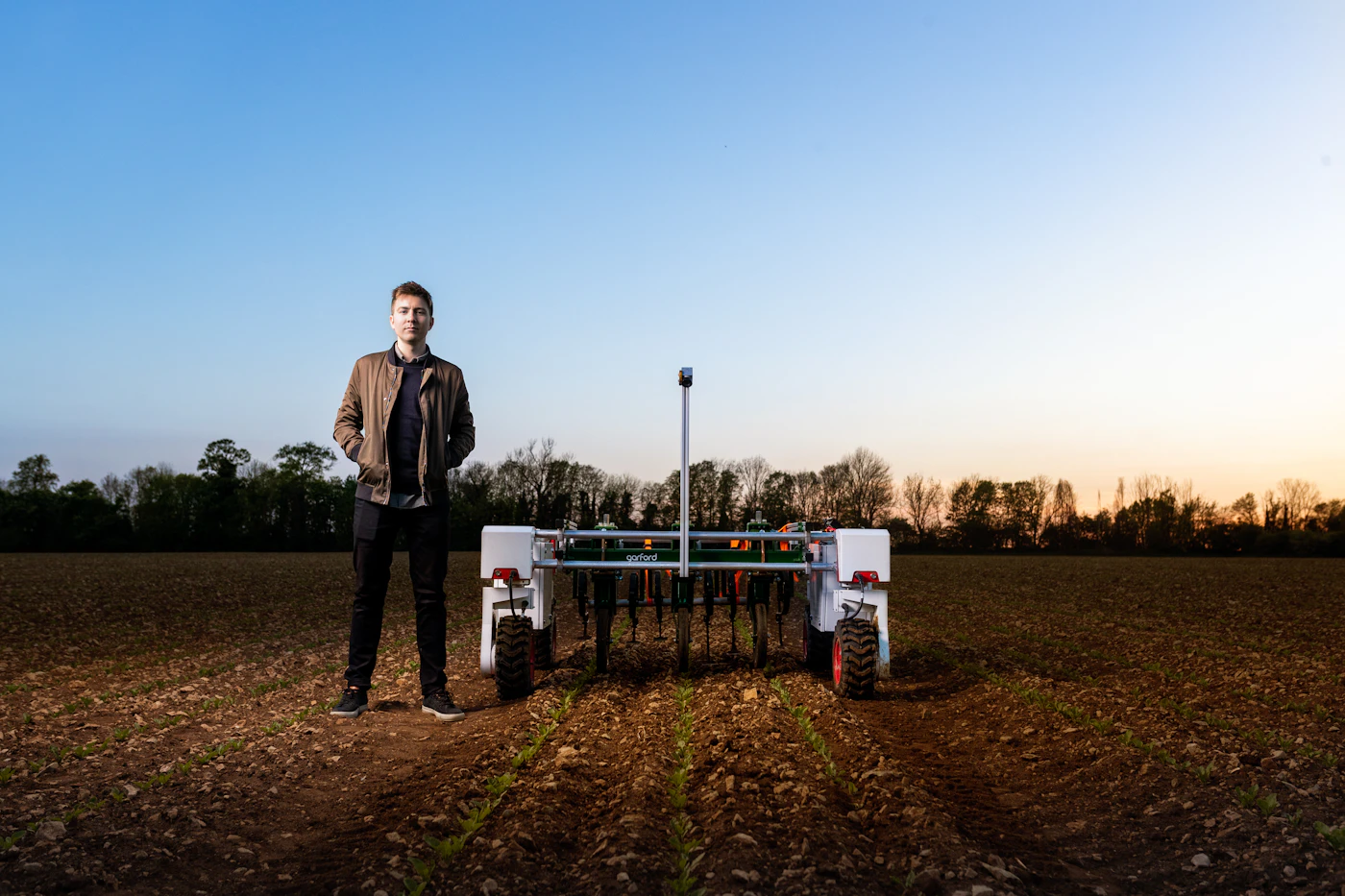 Ranger robot standing in a tilled field at dusk