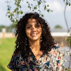 woman in blue and yellow floral shirt smiling