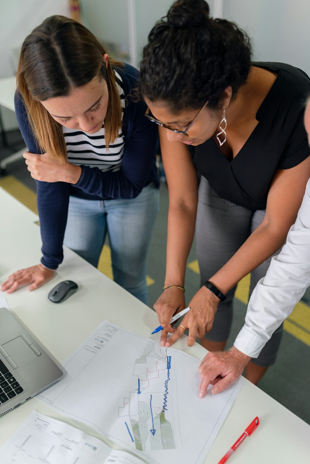 woman in black shirt and blue denim jeans writing on white paper