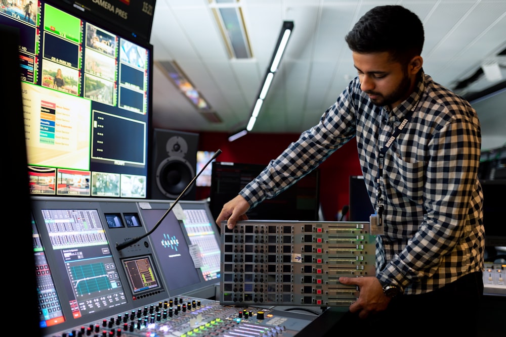 man in black and white checkered dress shirt playing dj controller