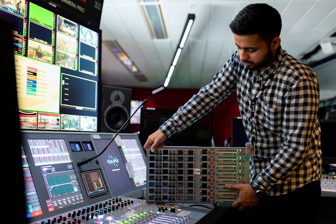 man in black and white checkered dress shirt playing dj controller