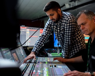 man in black and white checkered dress shirt playing dj mixer