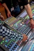 person in green and white checkered long sleeve shirt playing audio mixer