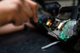 person holding green and black circuit board