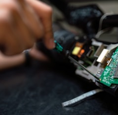 person holding green and black circuit board