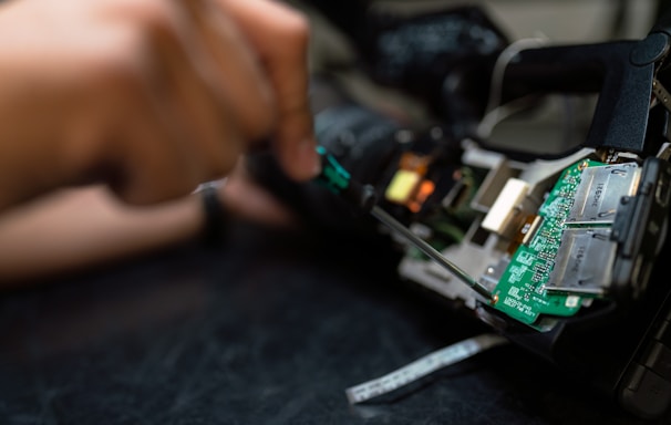 person holding green and black circuit board