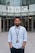 man in white button up shirt standing on sidewalk during daytime