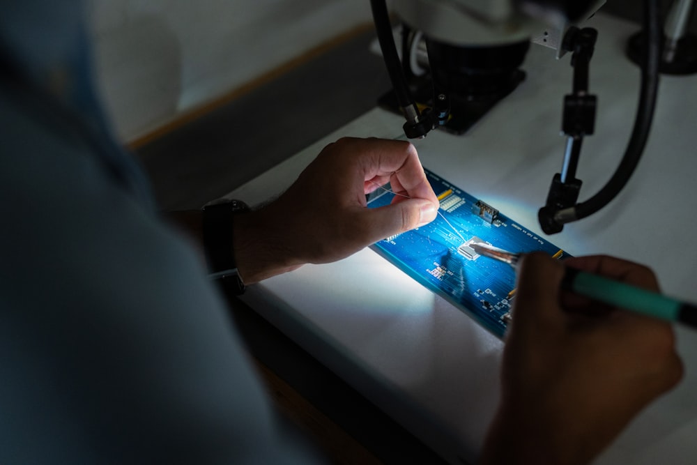 persona sosteniendo un juguete de plástico azul y negro