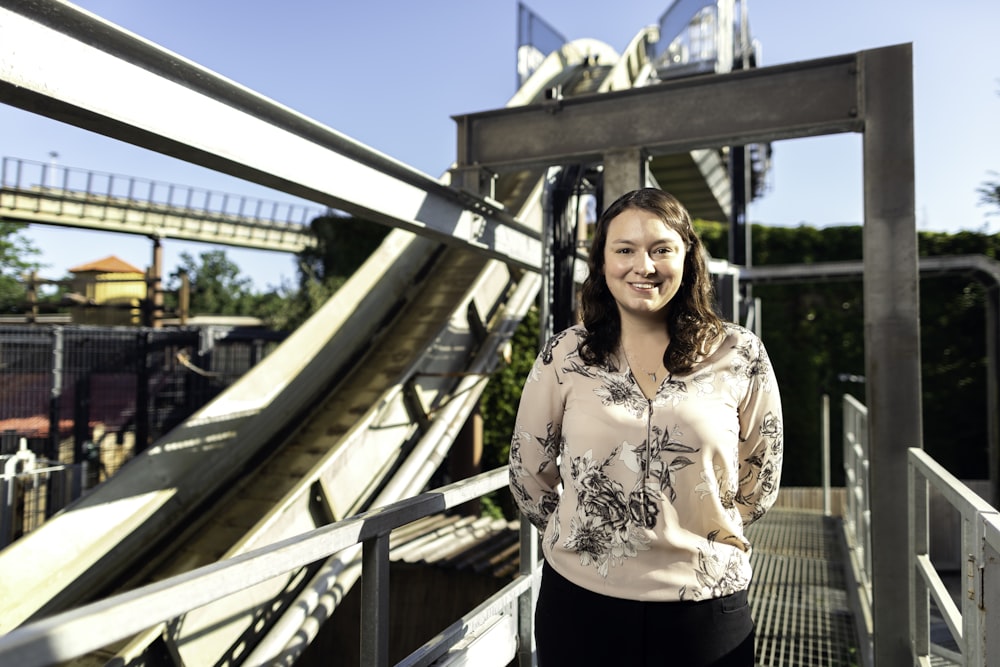 woman in white and black floral long sleeve shirt standing on bridge during daytime