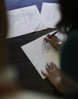 Close-up of hands holding architectural blueprints on site.