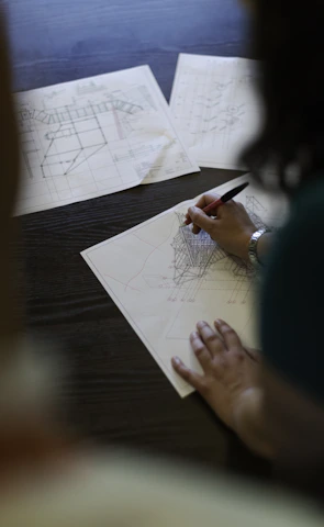 Close-up of hands holding architectural blueprints on site.