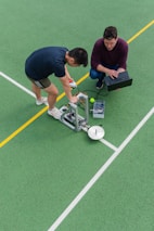 man in black crew neck t-shirt and blue denim jeans playing soccer