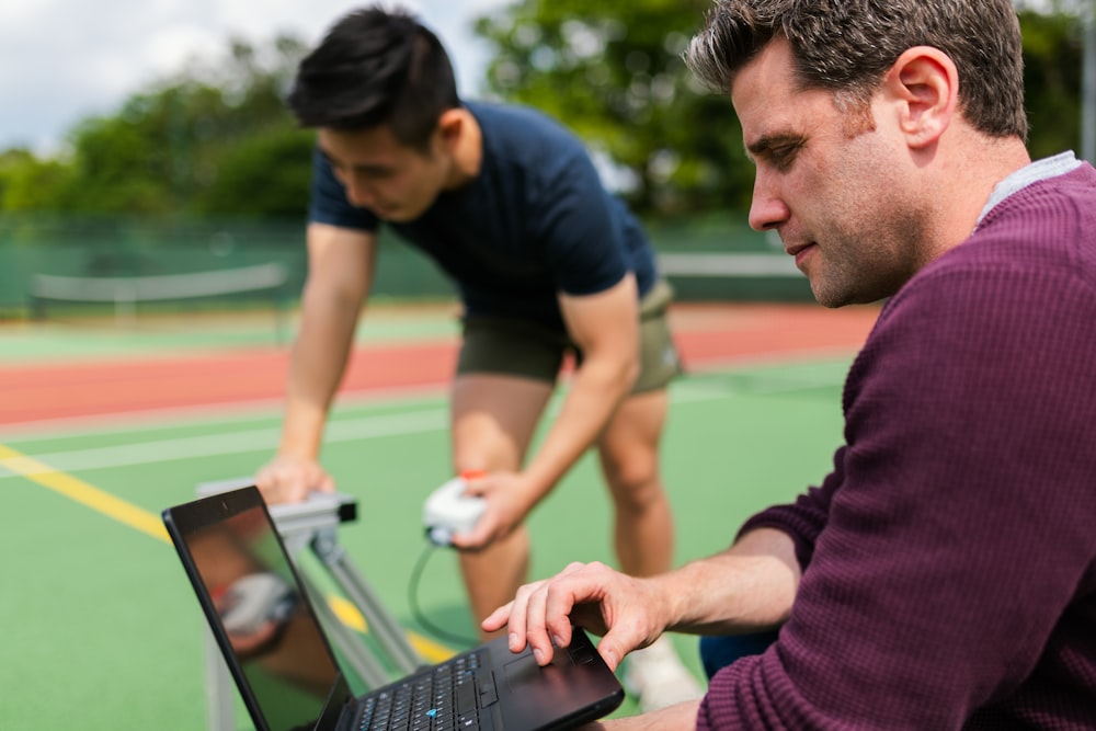 man in purple sweater using black laptop computer